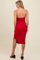 woman wearing a red maternity dress with ruching and shimmering details, showing a fitted silhouette from the back