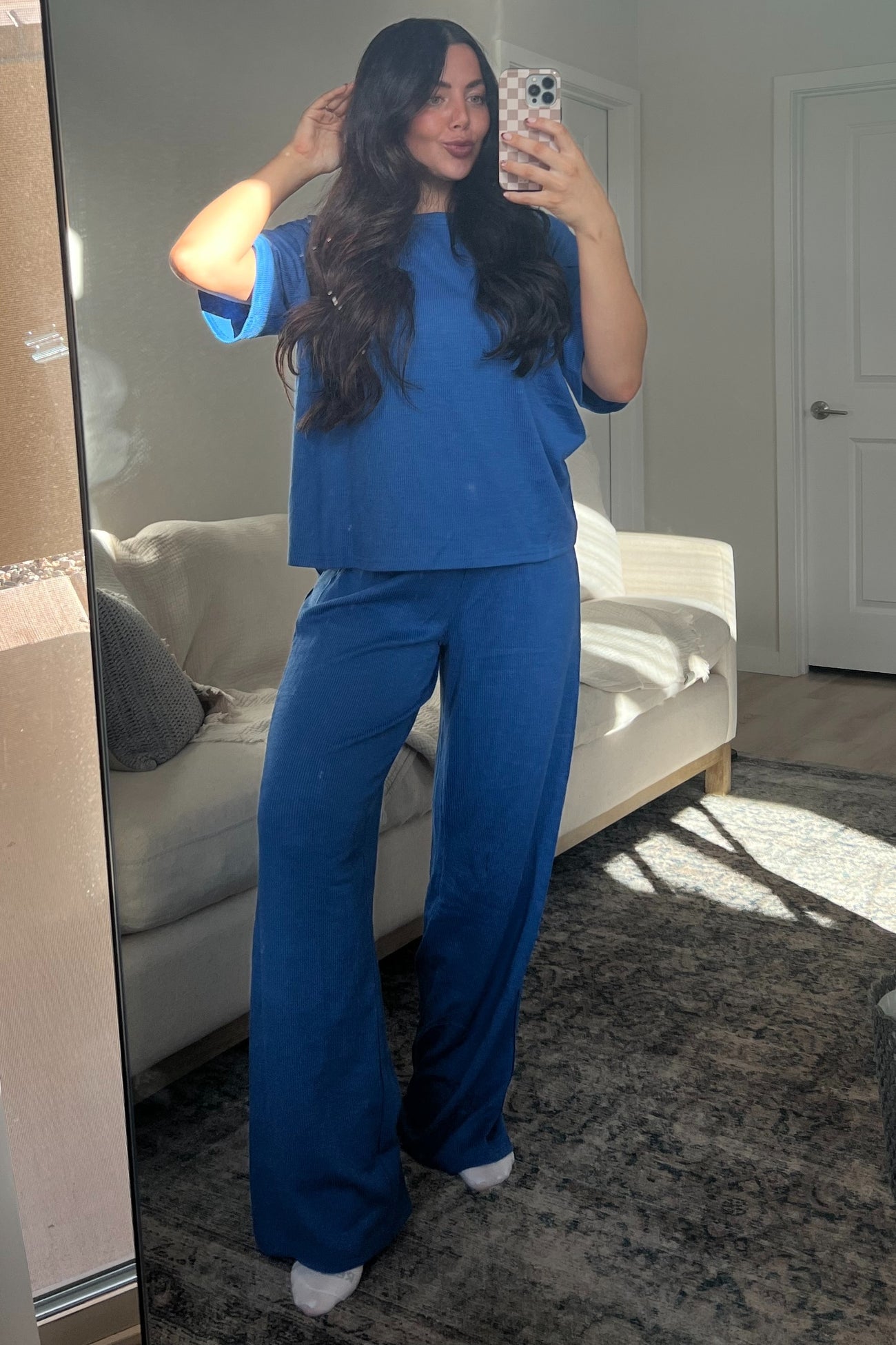 woman wearing a blue ribbed two-piece loungewear set with a relaxed fit and wide-leg pants, posing in front of a mirror