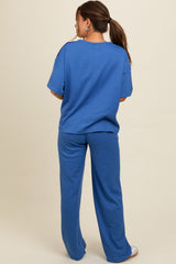 woman wearing a blue ribbed maternity lounge set, showing the back view with loose top and wide-leg pants