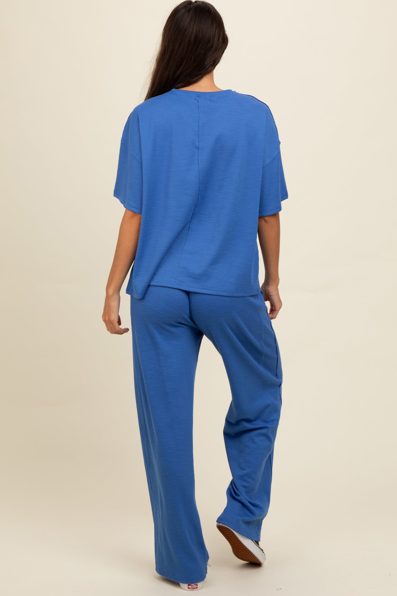 woman wearing a blue relaxed fit ribbed top and matching wide-leg pants, viewed from the back
