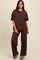 woman wearing a brown oversized knit lounge set with wide-leg pants and a relaxed fit top