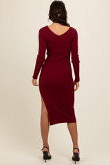 woman wearing a burgundy ribbed midi dress with long sleeves and a side slit, viewed from the back