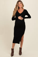 woman wearing a black ribbed maternity dress with a v-neck and side slit, highlighting her baby bump