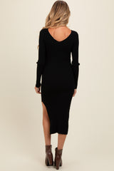 woman wearing a black ribbed long sleeve maternity dress with a high slit and a v-back design