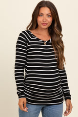 woman wearing a black and white striped maternity top with a scoop neckline and a fitted silhouette, baby bump visible