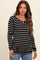 woman wearing a black and white striped maternity top with a scoop neckline and a fitted silhouette, baby bump visible