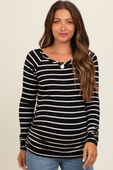 woman wearing a black and white striped maternity top with long sleeves and a scoop neck