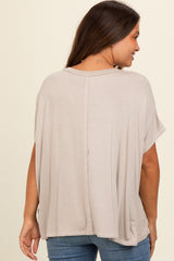 woman wearing a beige maternity top with short sleeves and a relaxed fit, shown from the back