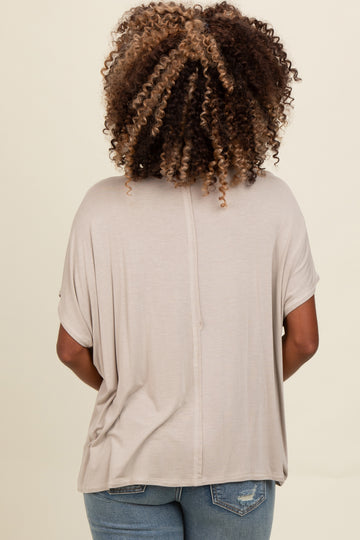 woman wearing a taupe short sleeve loose fit top with a round neckline, viewed from the back