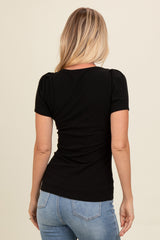 woman wearing a black ribbed short sleeve top with puffed sleeves and paired with blue jeans