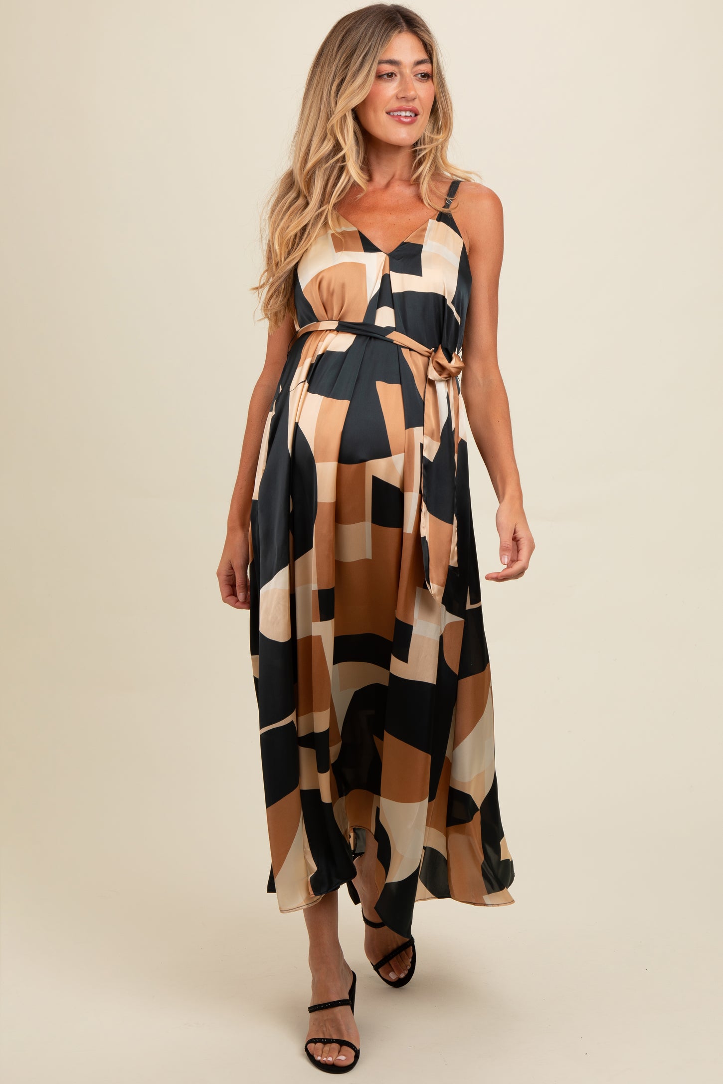 woman wearing a maternity maxi dress with a geometric pattern and a tied waist, showcasing her baby bump