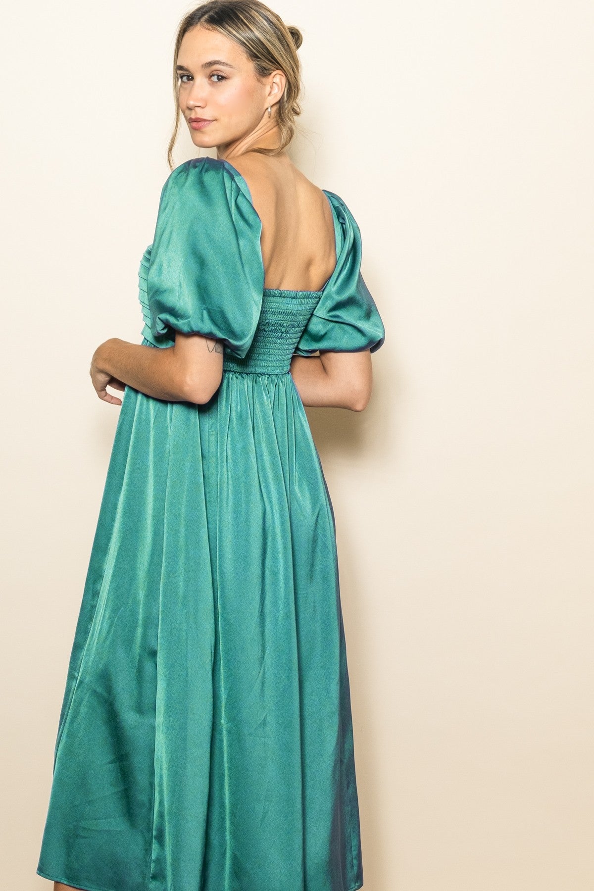 woman wearing a teal puff sleeve midi dress with a smocked back detail
