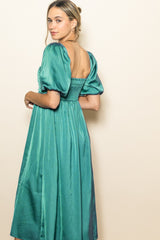 woman wearing a teal puff sleeve midi dress with a smocked back detail