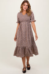 woman wearing a brown floral puff sleeve midi dress with a smocked bodice and a ruffled hem