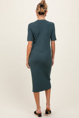 woman wearing a teal ribbed midi maternity dress with short sleeves, shown from the back