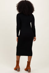 woman wearing a black ribbed long sleeve midi dress and brown ankle boots, seen from the back