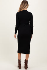 woman wearing a black ribbed maternity dress with long sleeves and a mid-length fit, showing a side view of her baby bump