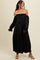 woman wearing a black off-the-shoulder maxi dress with ruched bodice and puff sleeves, styled with light-colored sandals