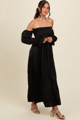 woman wearing a black off-the-shoulder maxi dress with puff sleeves and a fitted bodice