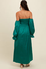 woman wearing a teal off-shoulder maxi dress with smocked bodice and puff sleeves, shown from the back