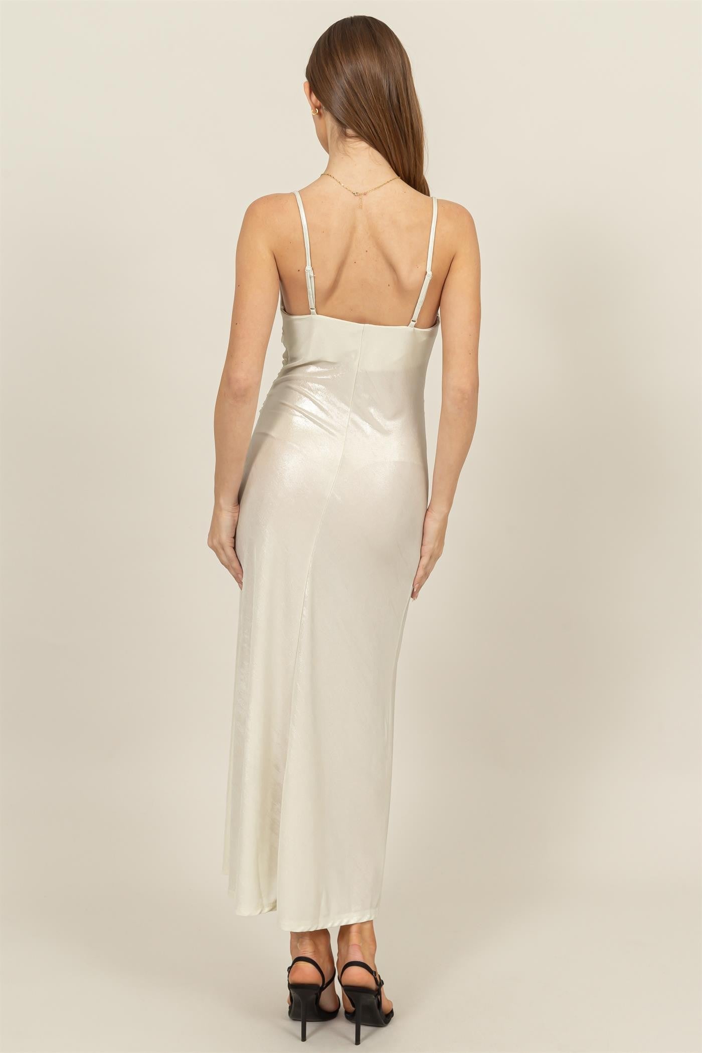 woman wearing a silver satin maxi dress with thin straps, viewed from the back