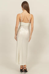 woman wearing a silver satin maxi dress with thin straps, viewed from the back