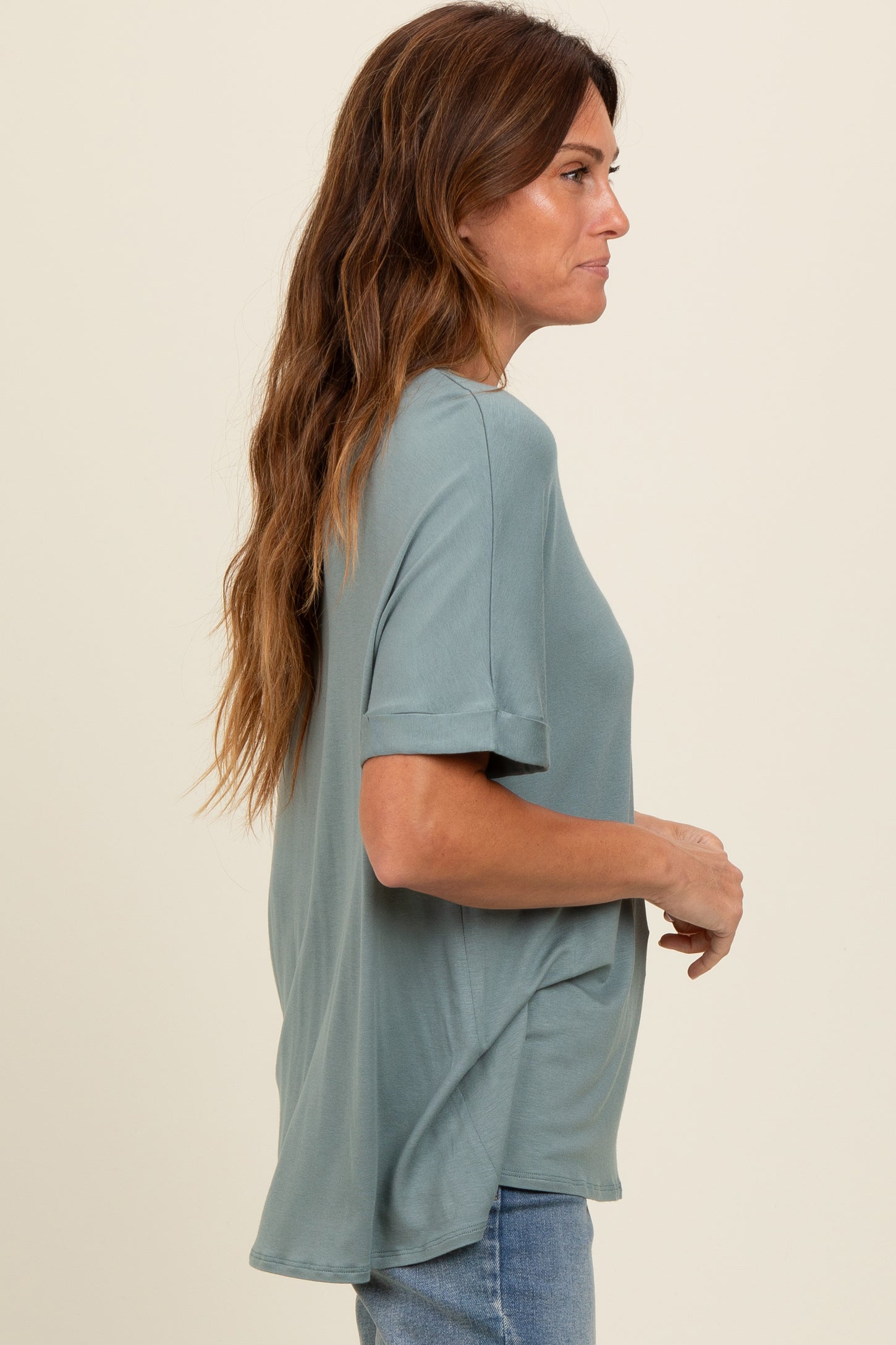 woman wearing a loose-fitting teal short sleeve top with a relaxed silhouette