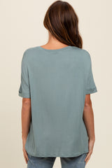 woman wearing a loose-fit sage green short sleeve top, seen from the back