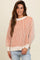 woman wearing a striped orange and cream oversized sweater with balloon sleeves and casual jeans