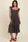 woman wearing a black floral print midi dress with ruffle sleeves and a smocked bodice