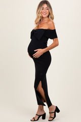 woman wearing a black off-the-shoulder maternity dress with a bow detail and side slit, highlighting her baby bump