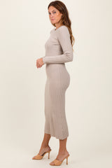 woman wearing a beige ribbed long sleeve midi dress with a pleated bottom and heeled sandals