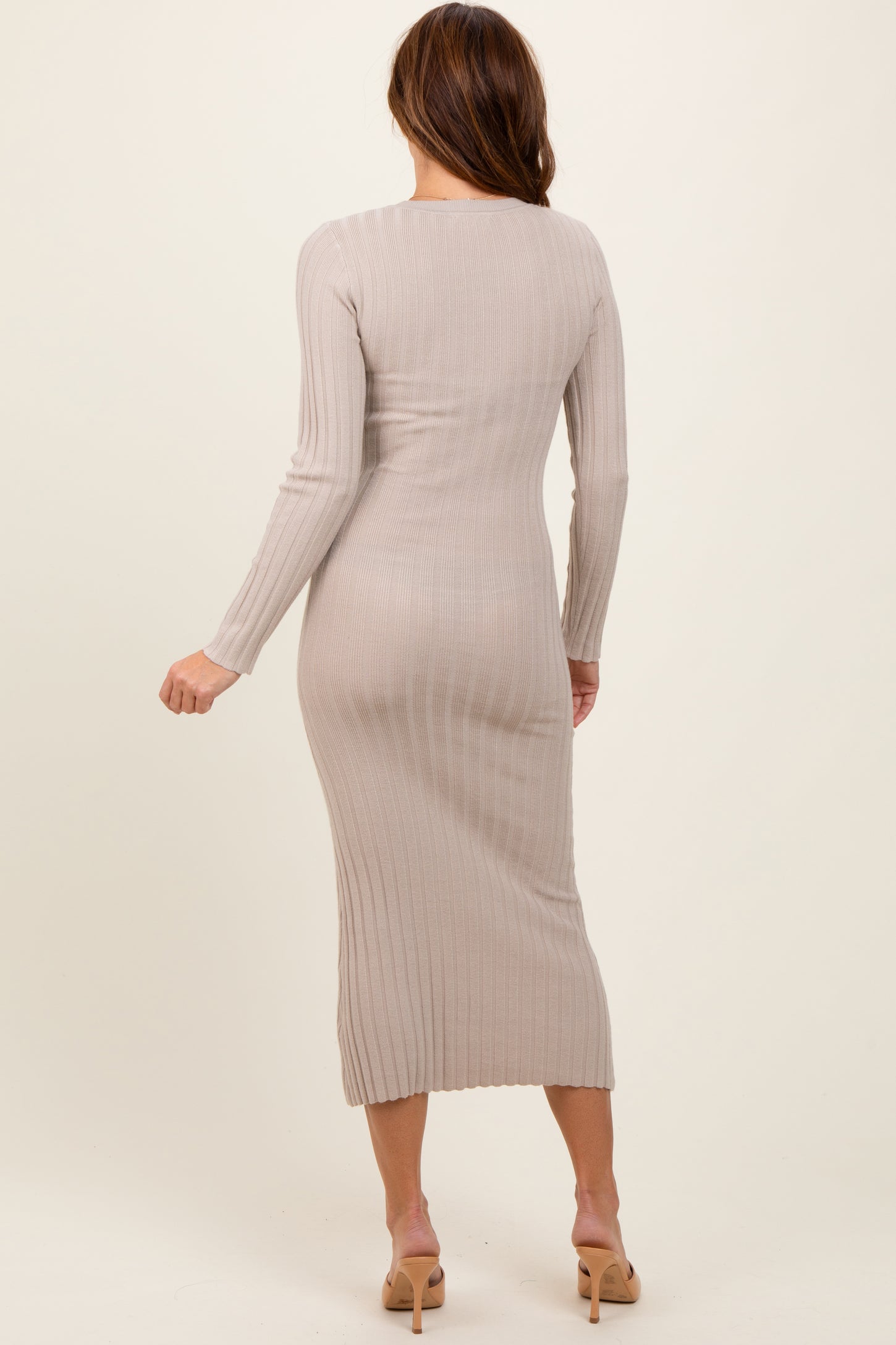 woman wearing a beige ribbed long sleeve midi dress, viewed from the back