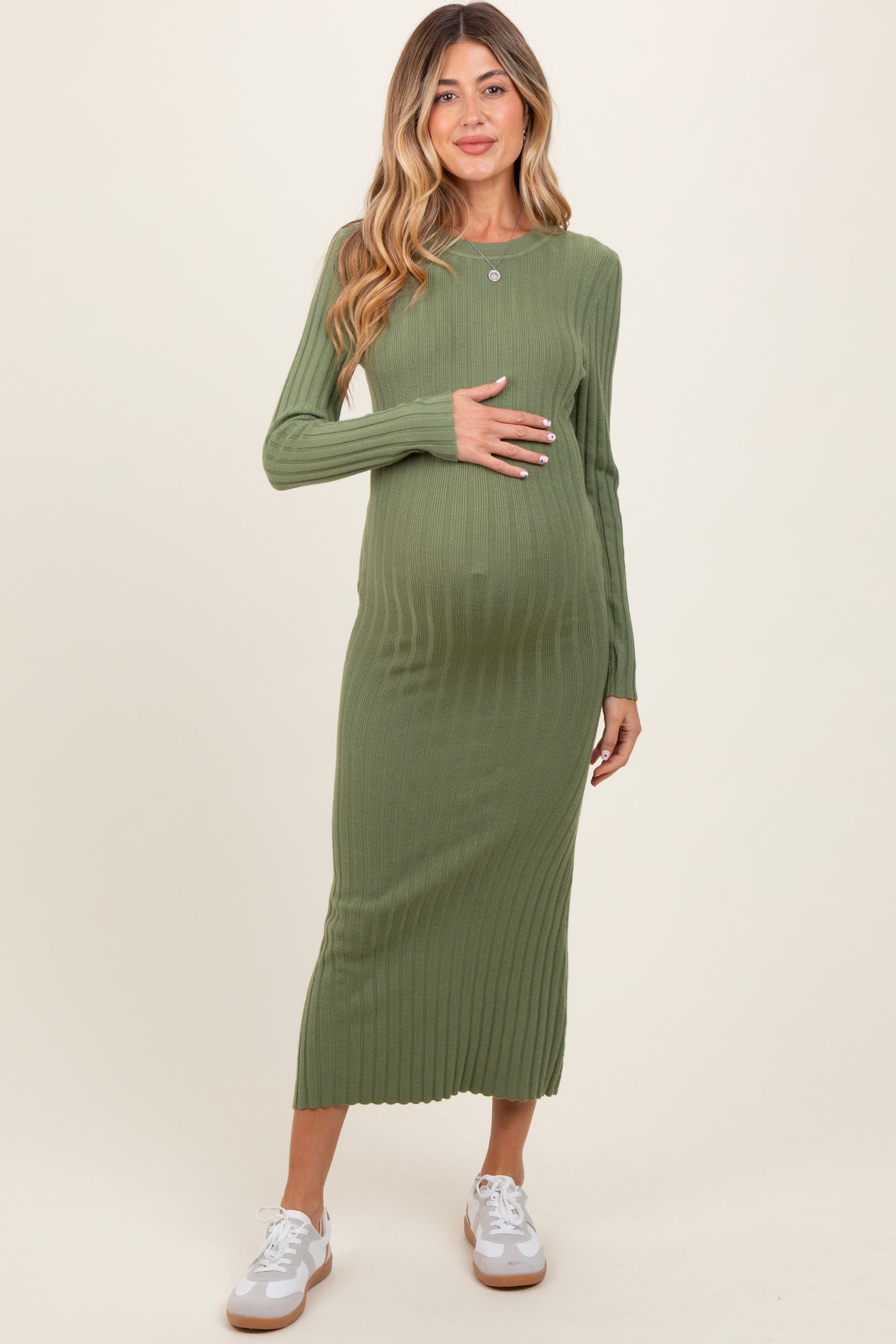 woman wearing a green ribbed maternity dress with long sleeves and a baby bump