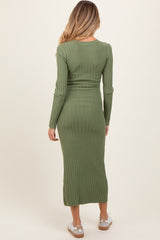 woman wearing an olive green ribbed maternity dress that falls to mid-calf, showing a fitted silhouette and long sleeves