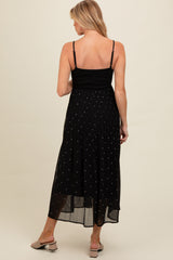 woman wearing a black maternity maxi dress with spaghetti straps and pleated skirt detailing, shown from the back