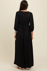 woman wearing a long black shimmer maxi dress with puff sleeves and a cinched waist, viewed from the back
