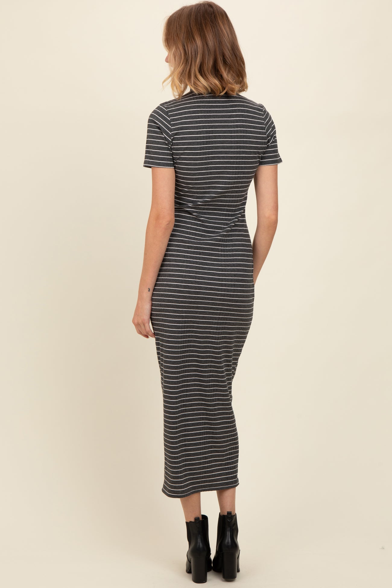 woman wearing a fitted gray striped midi dress with short sleeves and a round neckline