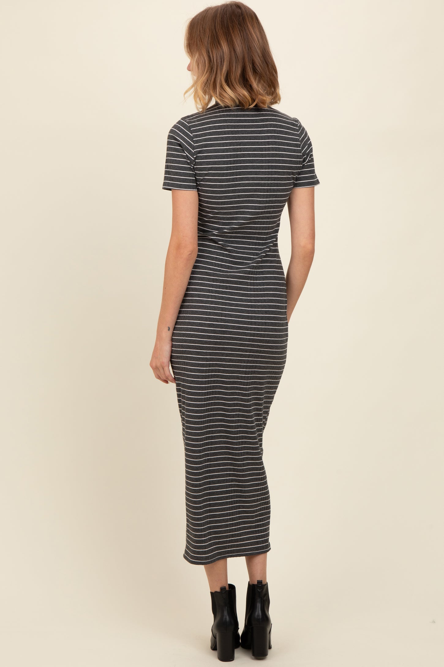 woman wearing a fitted gray striped midi dress with short sleeves and a round neckline