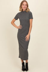woman wearing a black and white striped fitted midi dress with short sleeves and a high neckline