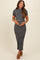 woman wearing a gray and white striped maternity dress with short sleeves and a fitted silhouette, holding her baby bump