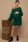 woman wearing a dark green off-shoulder maternity sweater dress with cable knit texture and a visible baby bump