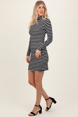 woman wearing a black and white striped long sleeve bodycon dress with a turtleneck and side pockets