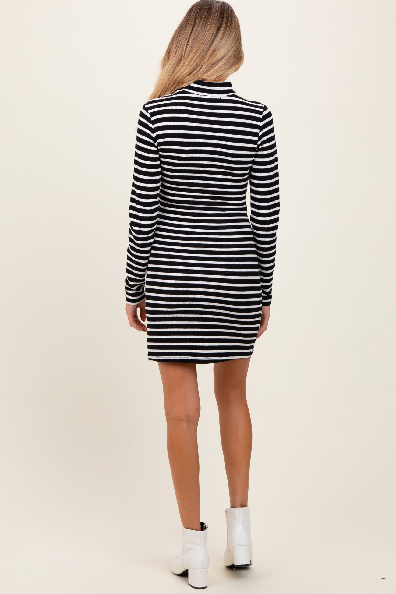 woman wearing a black and white striped long sleeve maternity dress, showing the back view