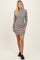 woman wearing a gray and white striped long sleeve mini dress with a high neck and black sneakers