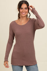 woman wearing a mauve long sleeve ribbed top with a rounded neckline and curved hemline