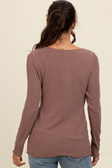 woman wearing a dusty mauve ribbed long sleeve top with a rounded neckline and frayed hem, seen from the back