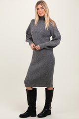 woman wearing a gray ribbed knit long sleeve sweater dress and black knee-high boots