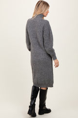 woman wearing a gray knitted sweater dress with a high collar and long sleeves, viewed from the back