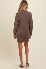 woman wearing a brown maternity sweater dress with long sleeves, shown from the back